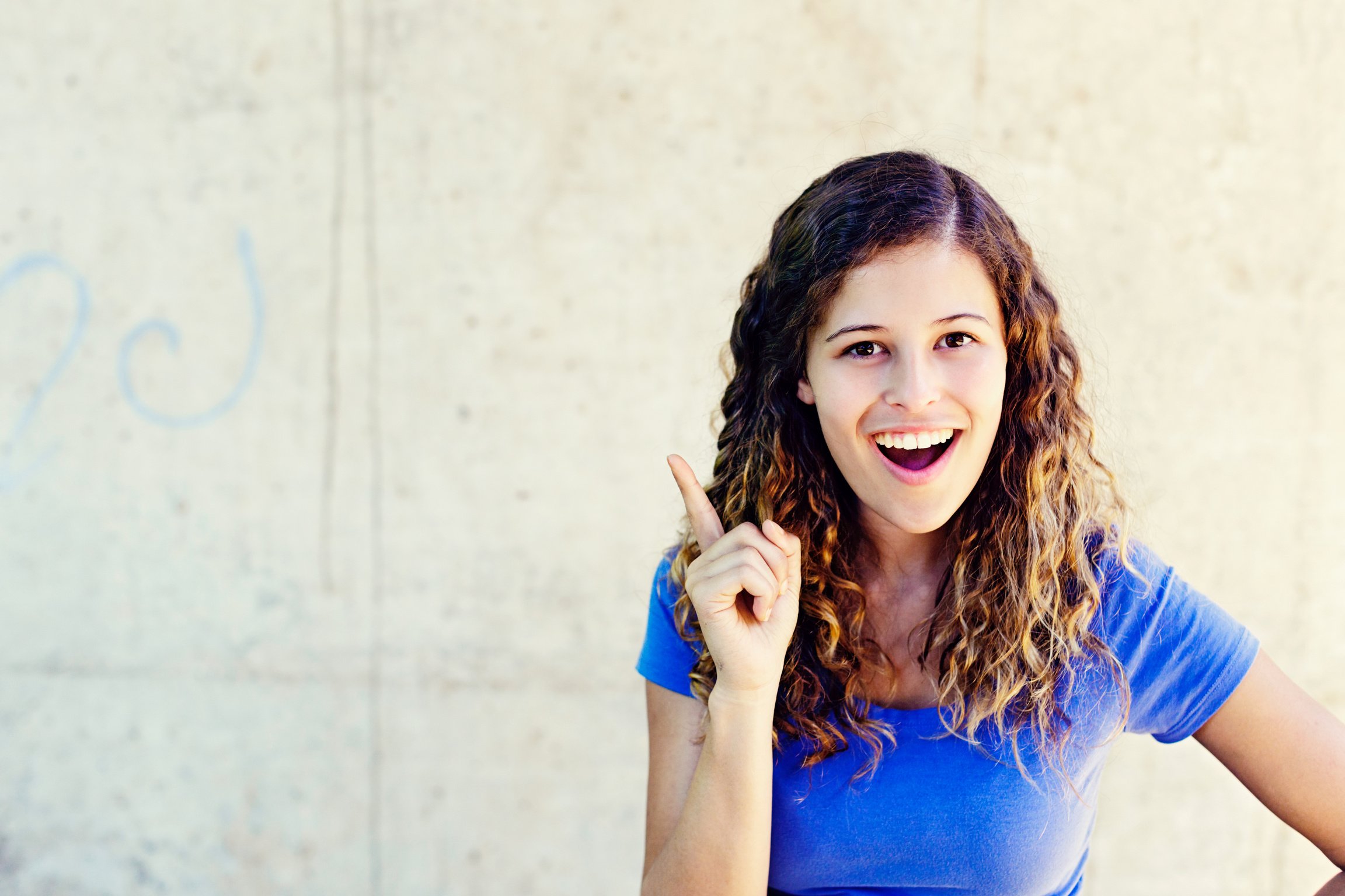 Aha! Smiling young beauty raises a finger in inspired delight